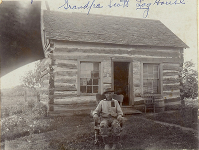 William Henry Scott in front of his log home